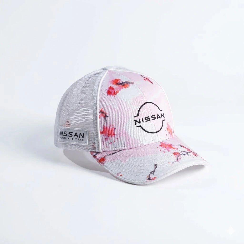 Gorra publicitaria tipo trucker de Nissan Formula E Team, color rosa pastel con diseño de flores de cerezo (Sakura), malla blanca, parche lateral y logotipo central.